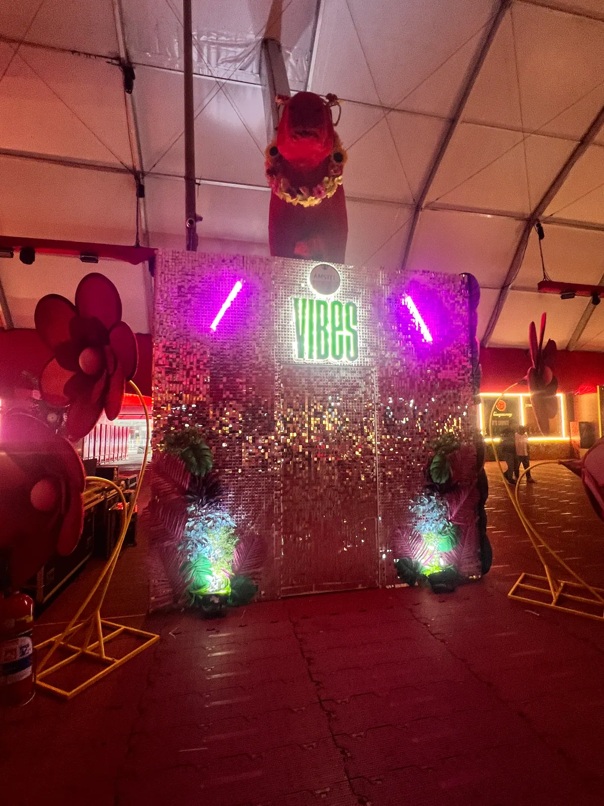 Painel de lantejoulas com logo da Amstel e letreiros iluminados em evento — foto 4
