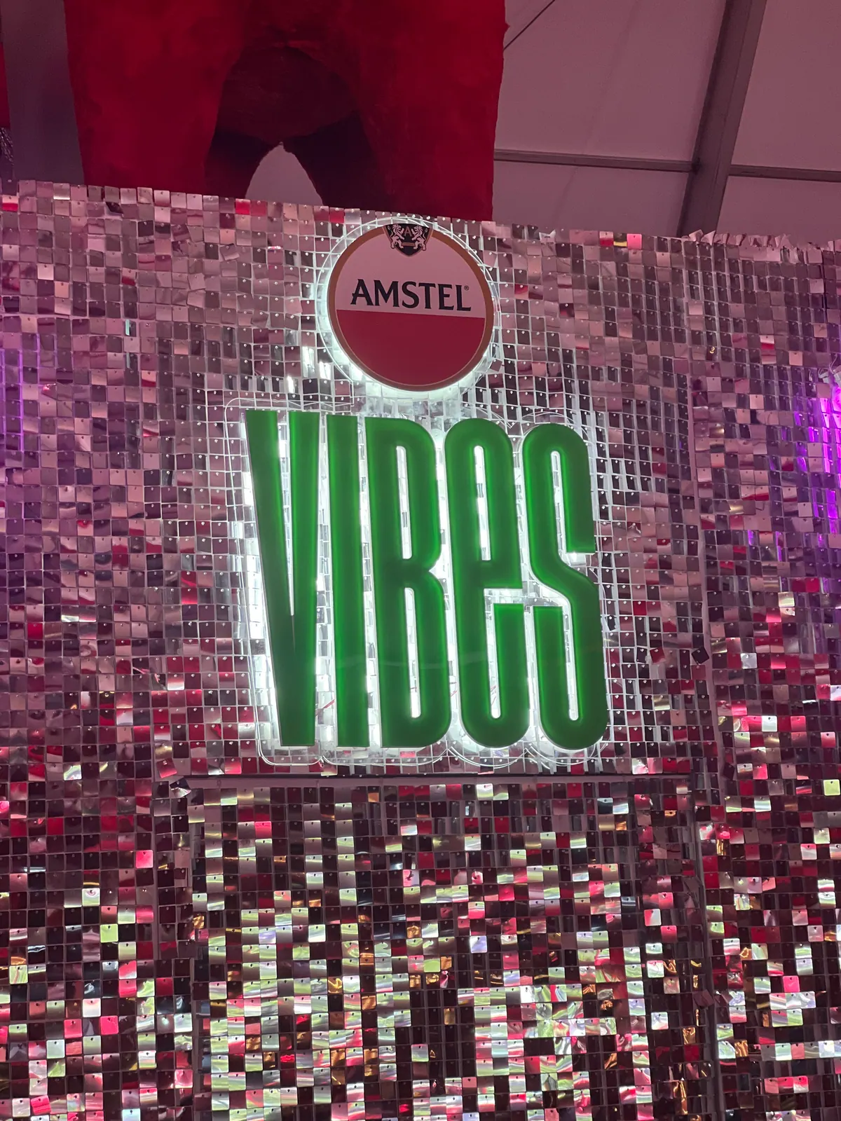 Painel de lantejoulas com logo da Amstel e letreiros iluminados em evento — foto 5