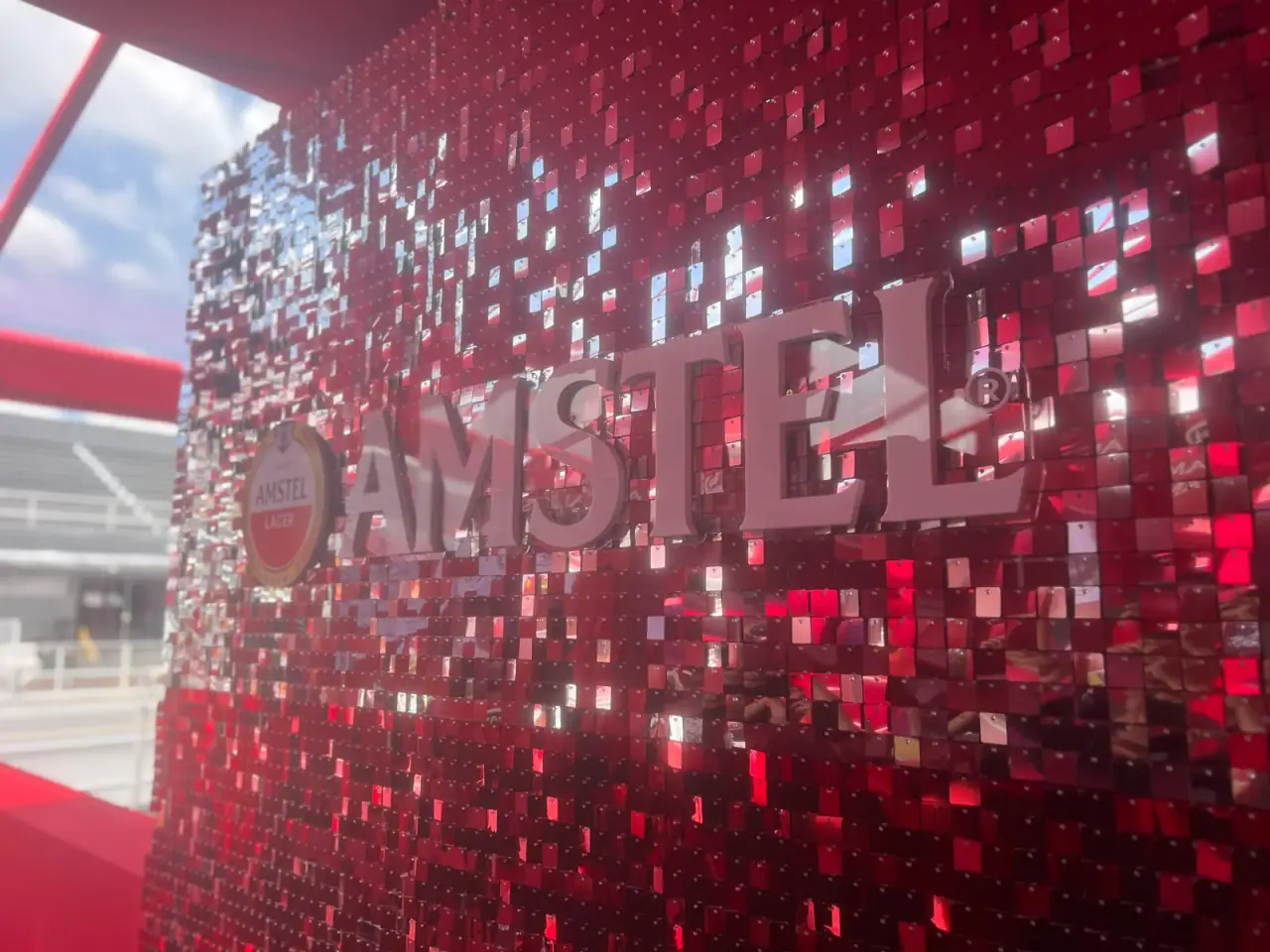Painel de lantejoulas com logo da Amstel e letreiros iluminados em evento — foto 6