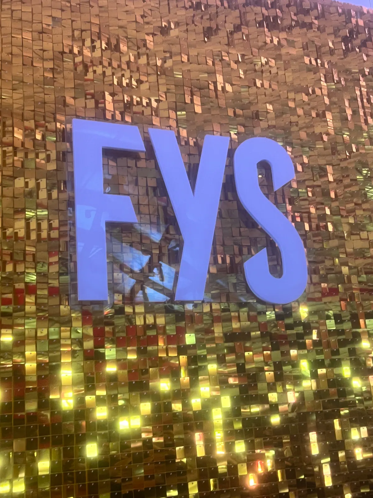 Letras iluminadas FYS sobre painel de lantejoulas douradas — foto 3