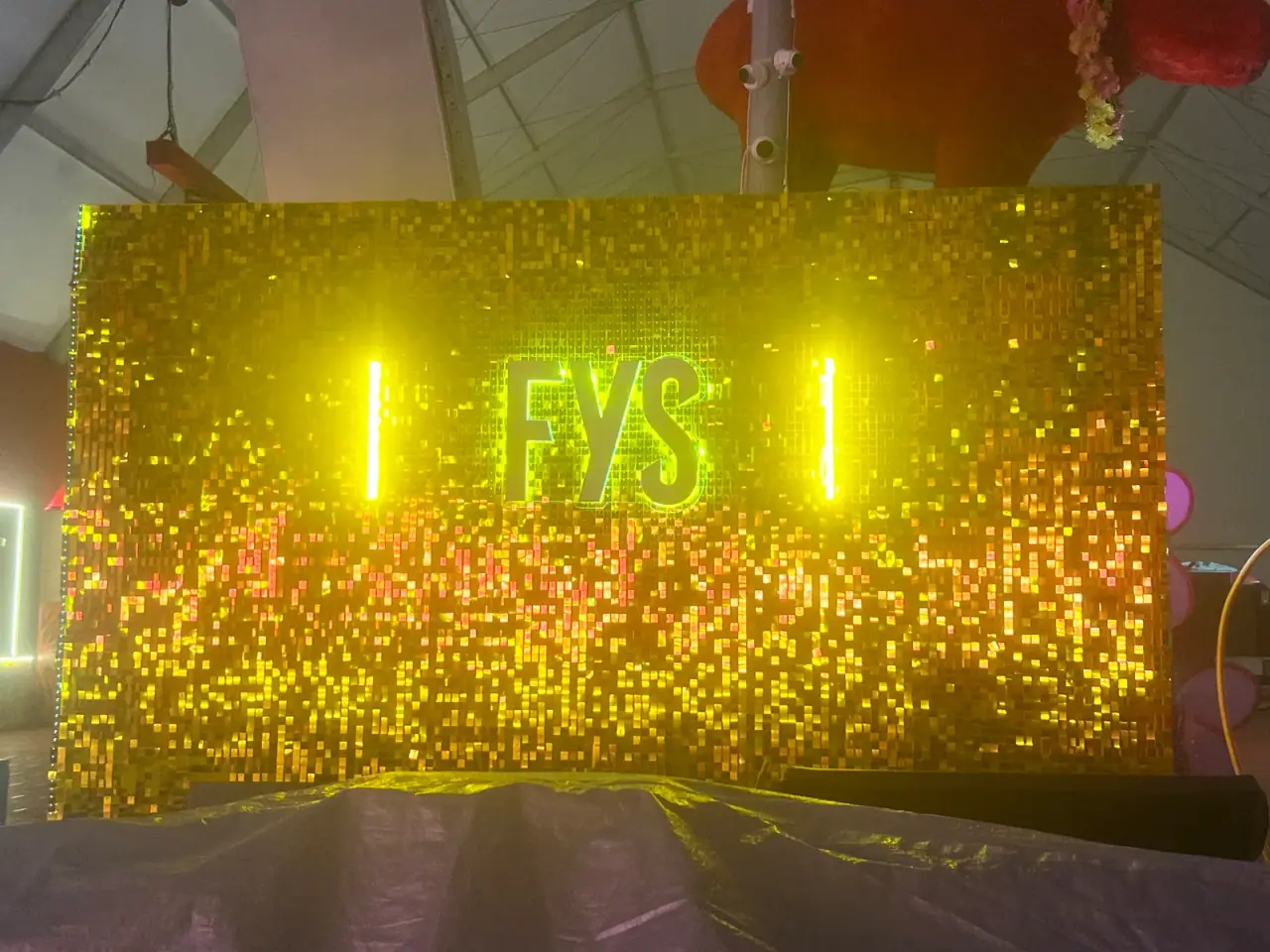 Letras iluminadas FYS sobre painel de lantejoulas douradas — foto 5