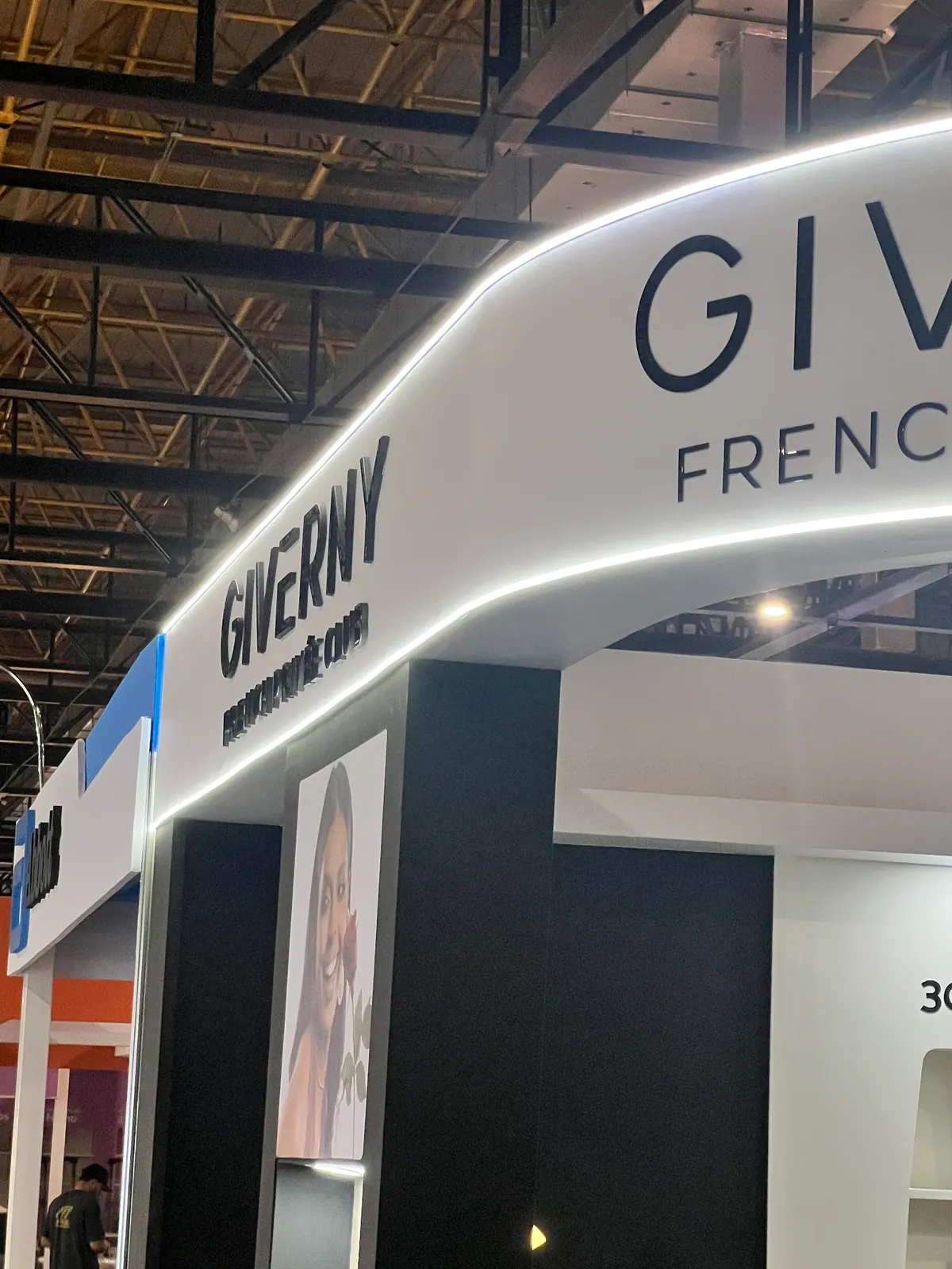 Stand da Giverny com testeira curva iluminada e nichos expositores — foto 4
