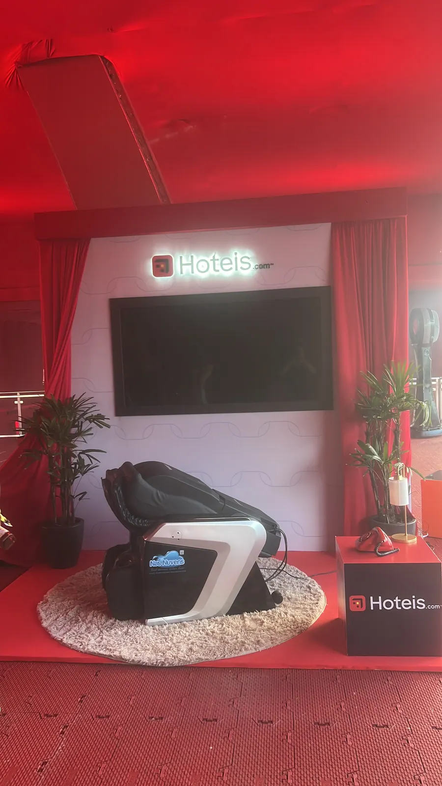 Lounge cenográfico da Hoteis.com com luminoso e cortinas vermelhas