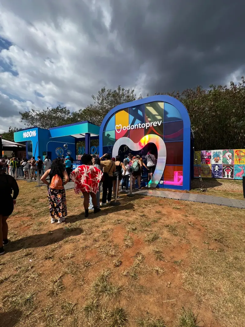 Espaço da Odontoprev em festival com entrada em coração iluminado e cenário de neon — foto 1