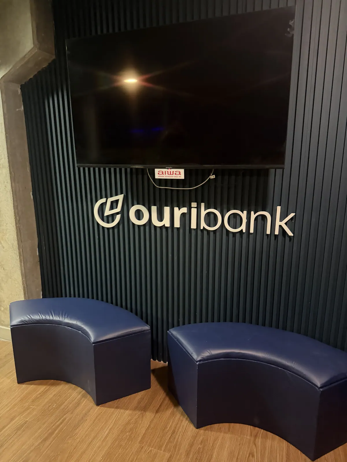 Camarote do Ouribank em estádio com painéis ripados e logotipo em relevo — foto 4