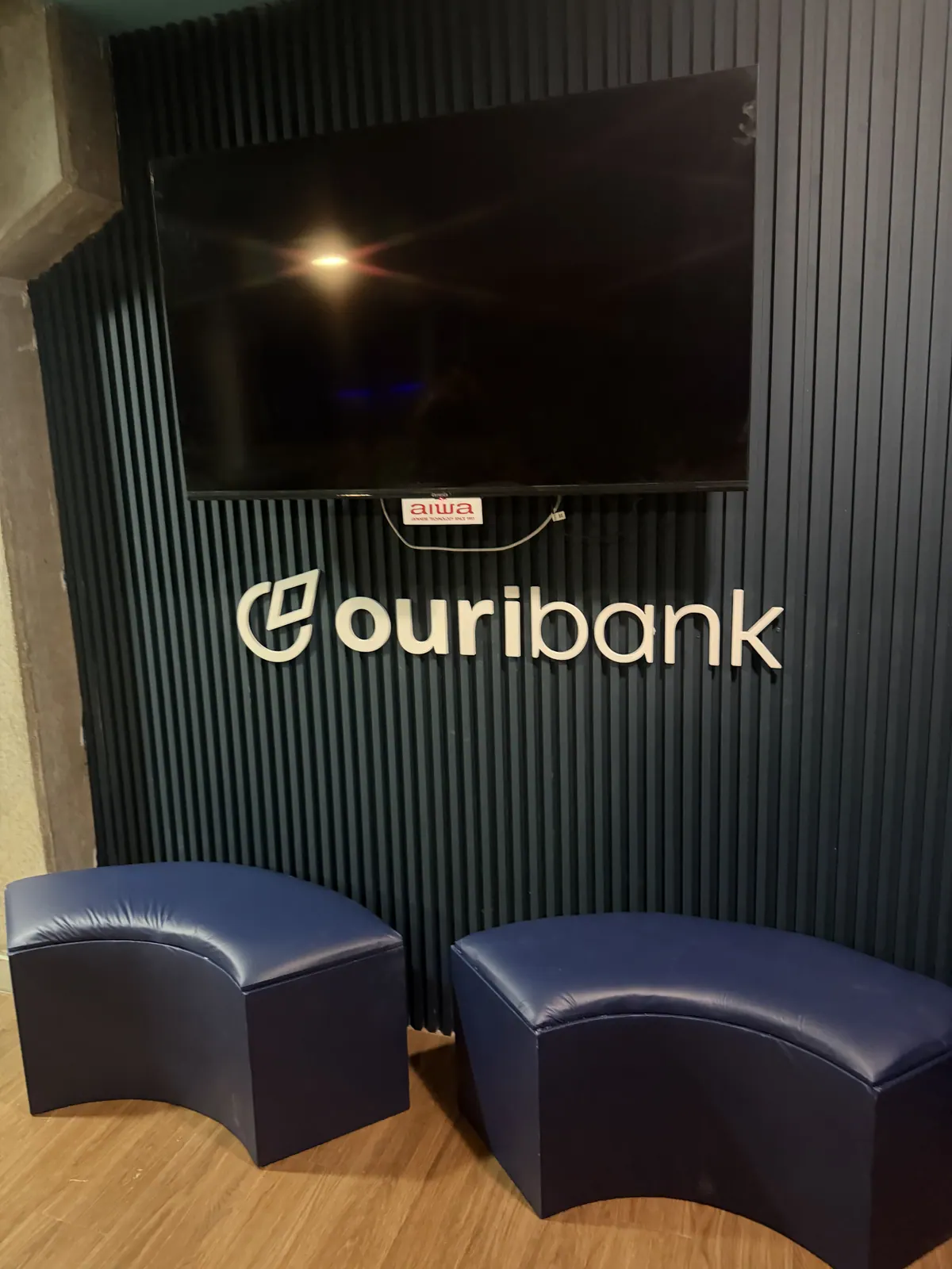 Camarote do Ouribank em estádio com painéis ripados e logotipo em relevo — foto 7