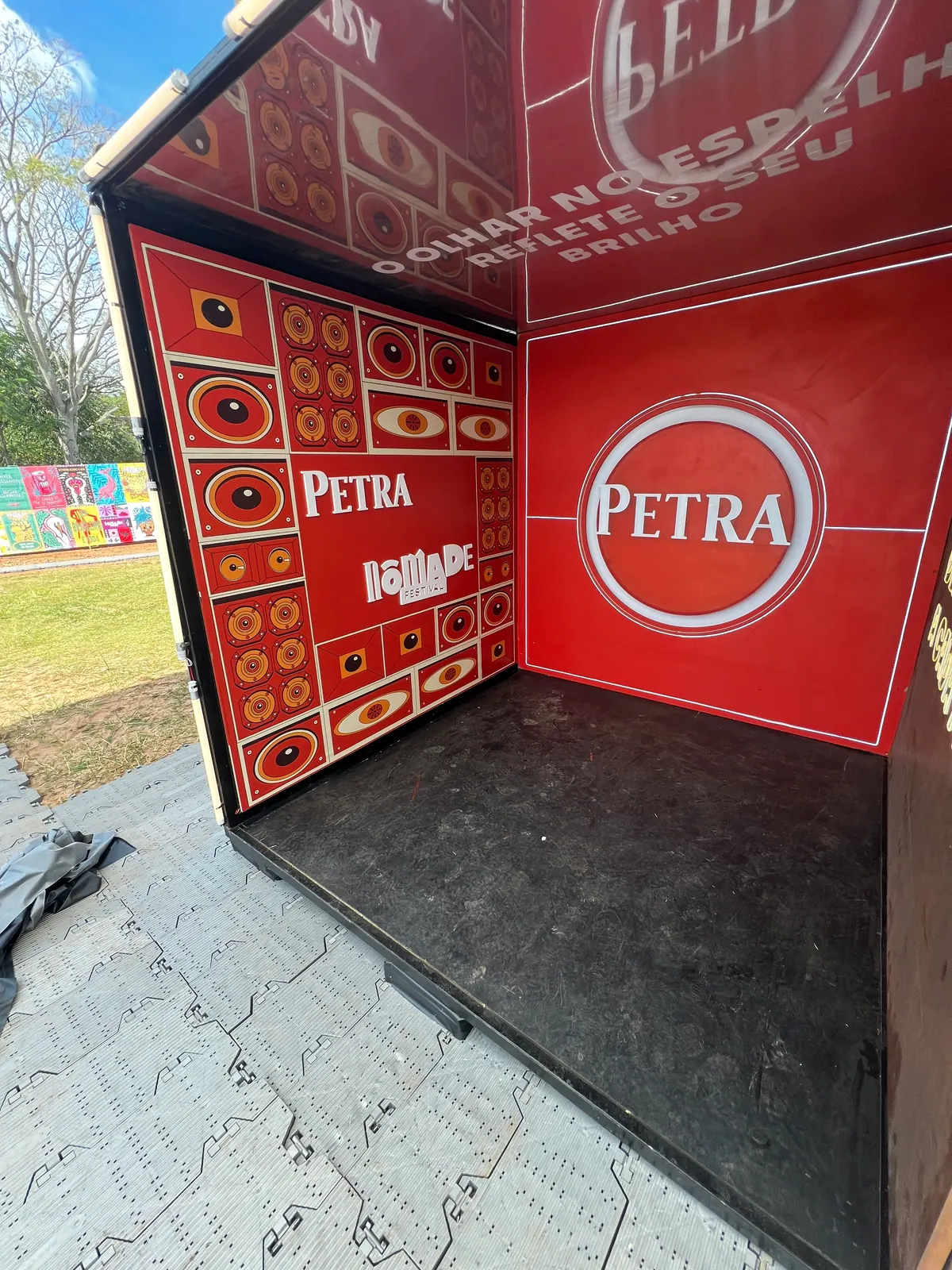 Ativação cenográfica da Petra em festival, com portal temático, bar e letreiros iluminados — foto 3