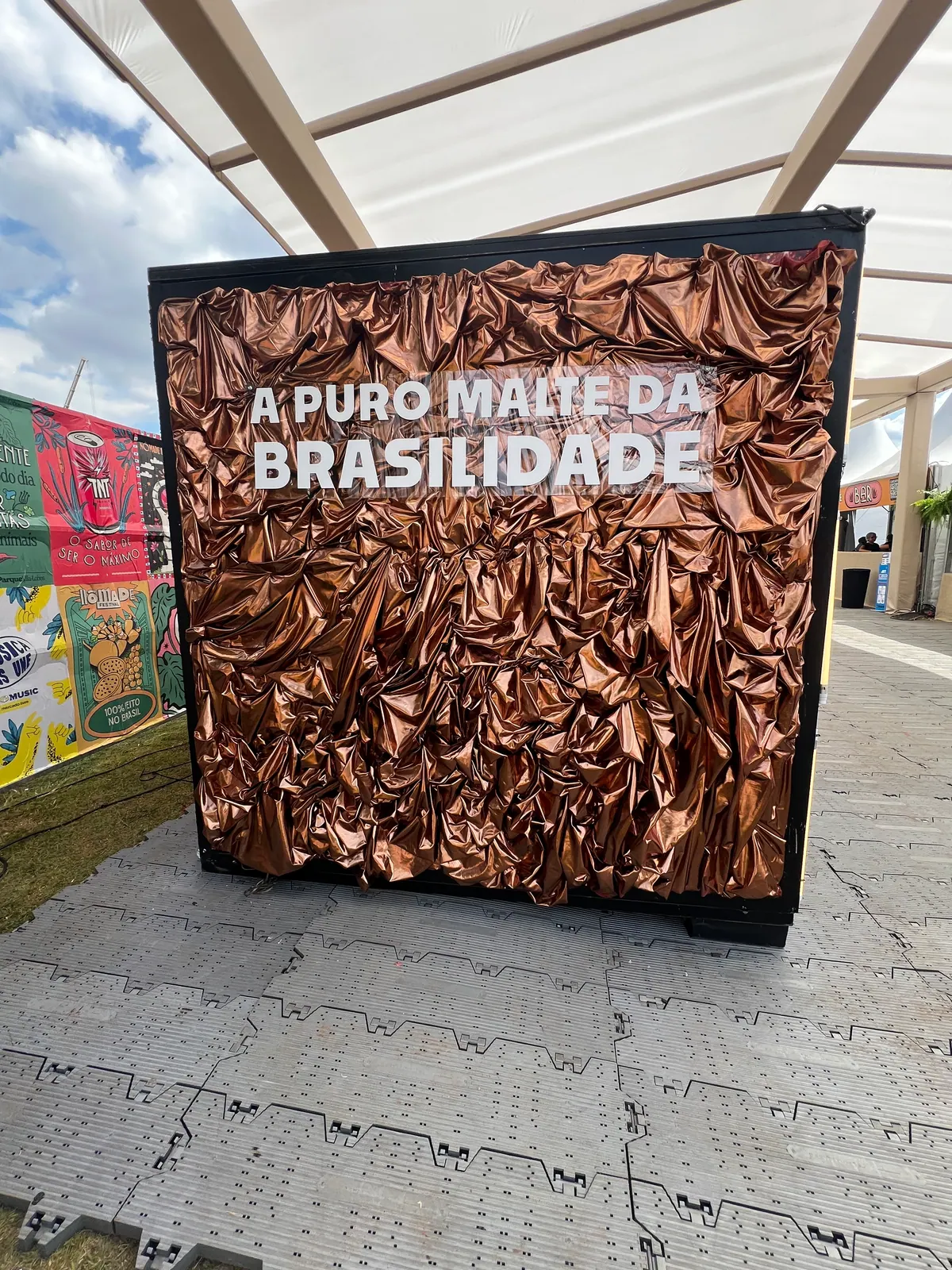 Ativação cenográfica da Petra em festival, com portal temático, bar e letreiros iluminados — foto 5