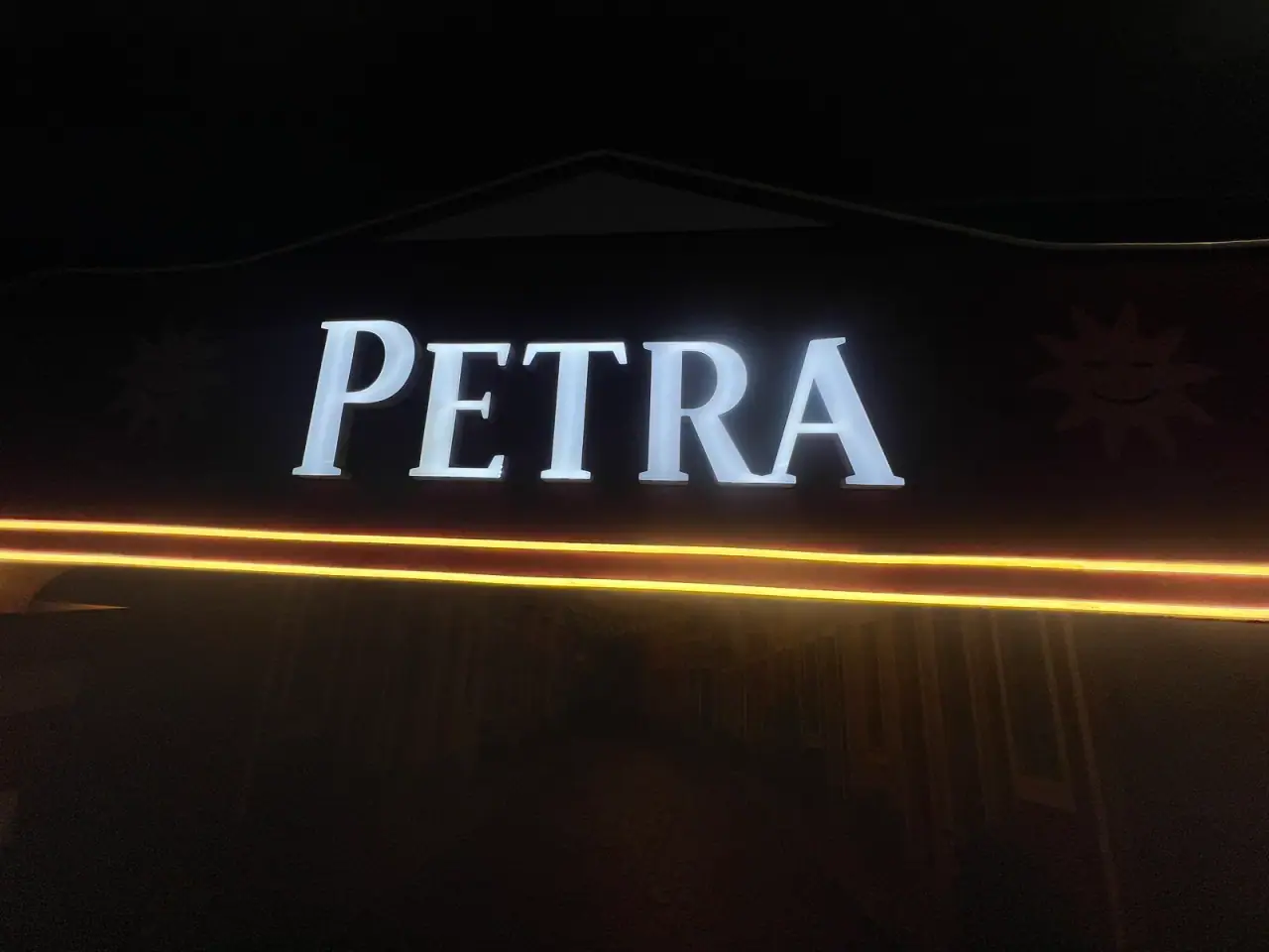 Ativação cenográfica da Petra em festival, com portal temático, bar e letreiros iluminados — foto 6
