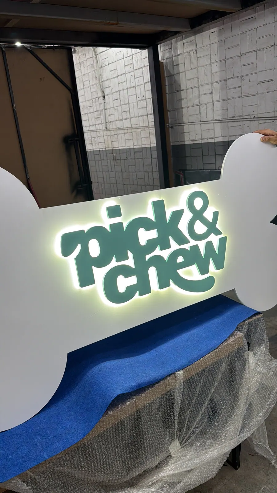 Letreiro em formato de osso da Pick & Chew com halo iluminado