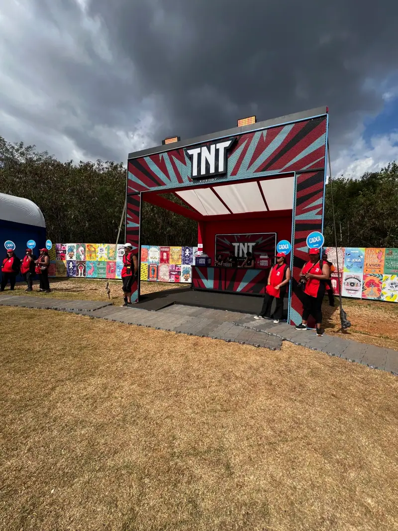 Estruturas de ativação da TNT em festival com portais de neon e bar cenográfico — foto 1