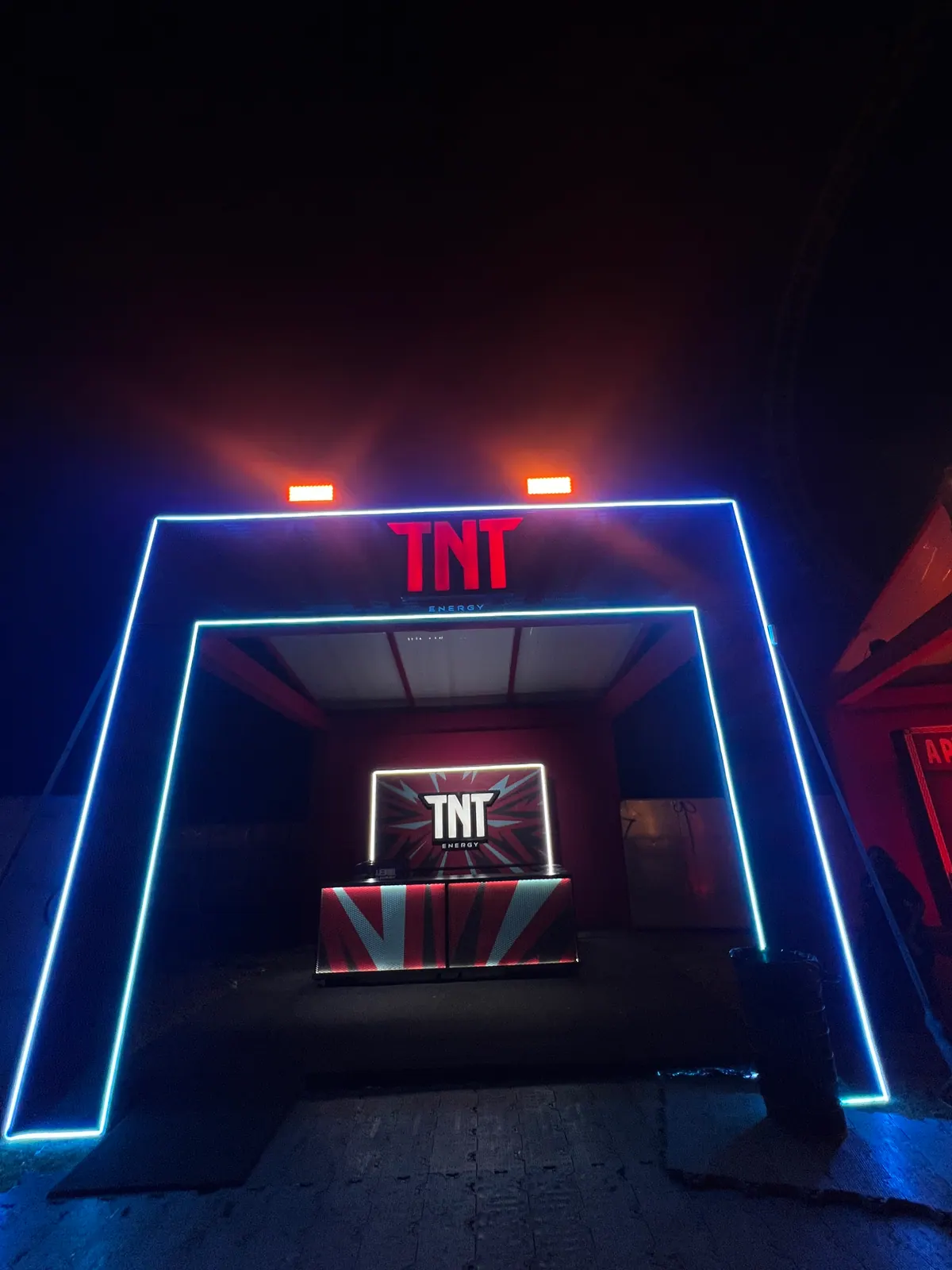 Estruturas de ativação da TNT em festival com portais de neon e bar cenográfico — foto 2