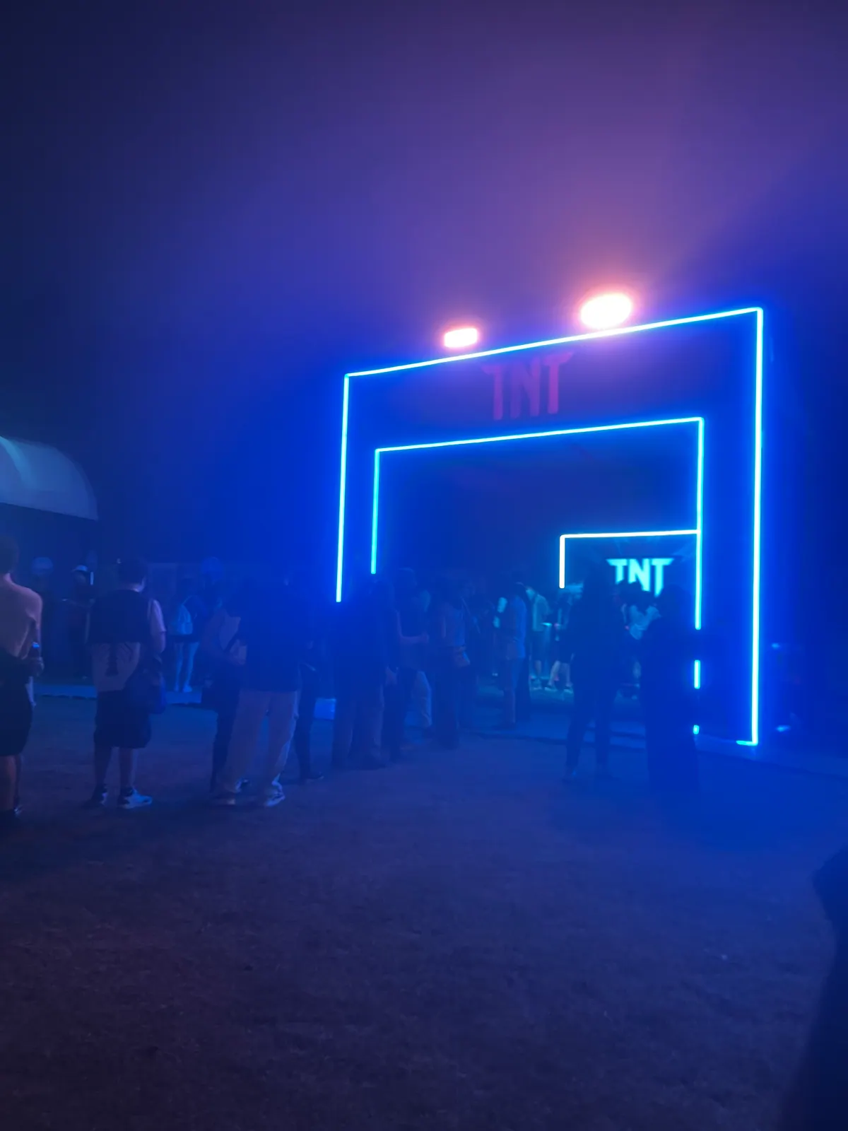 Estruturas de ativação da TNT em festival com portais de neon e bar cenográfico — foto 4