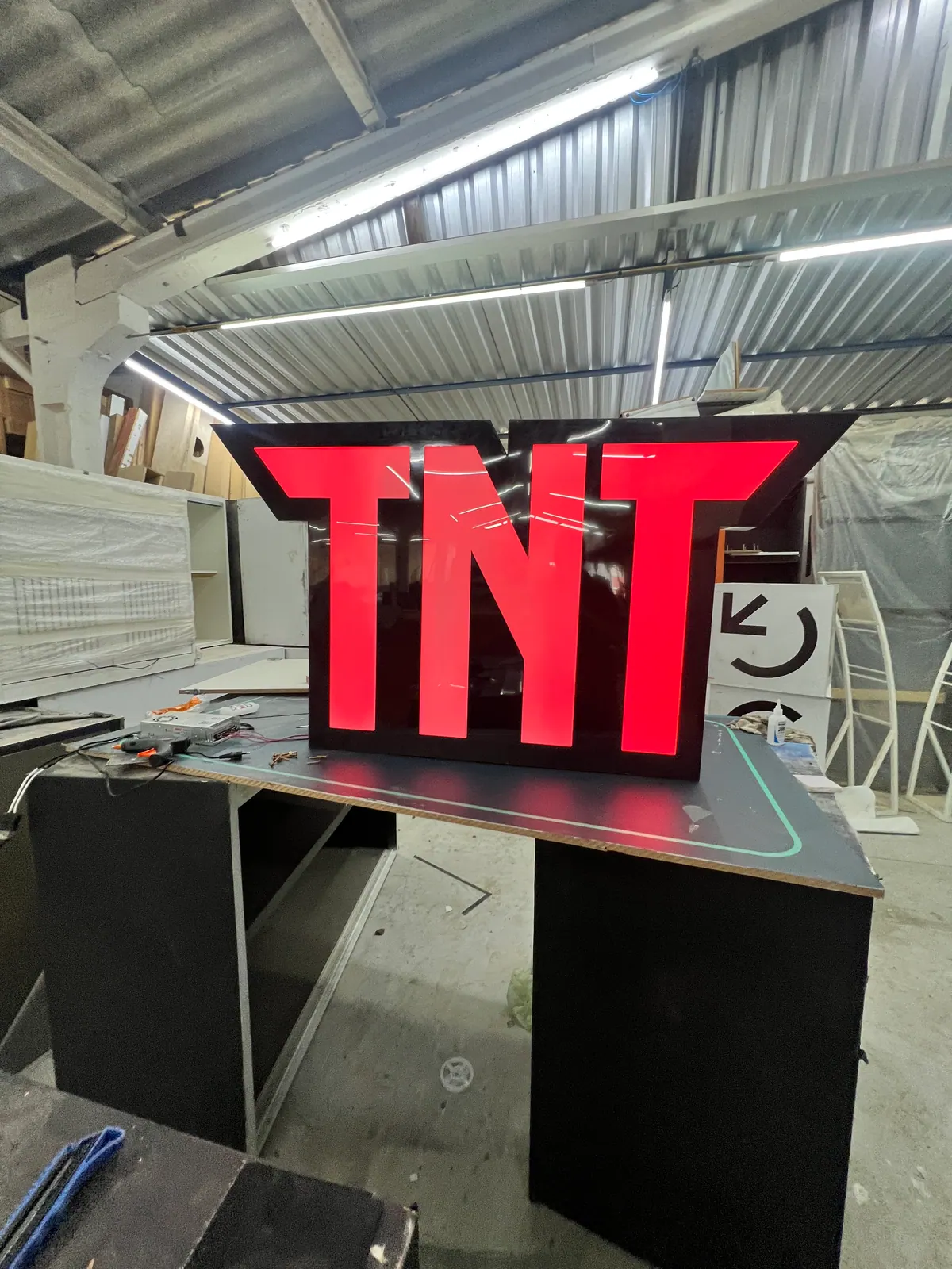 Estruturas de ativação da TNT em festival com portais de neon e bar cenográfico — foto 7