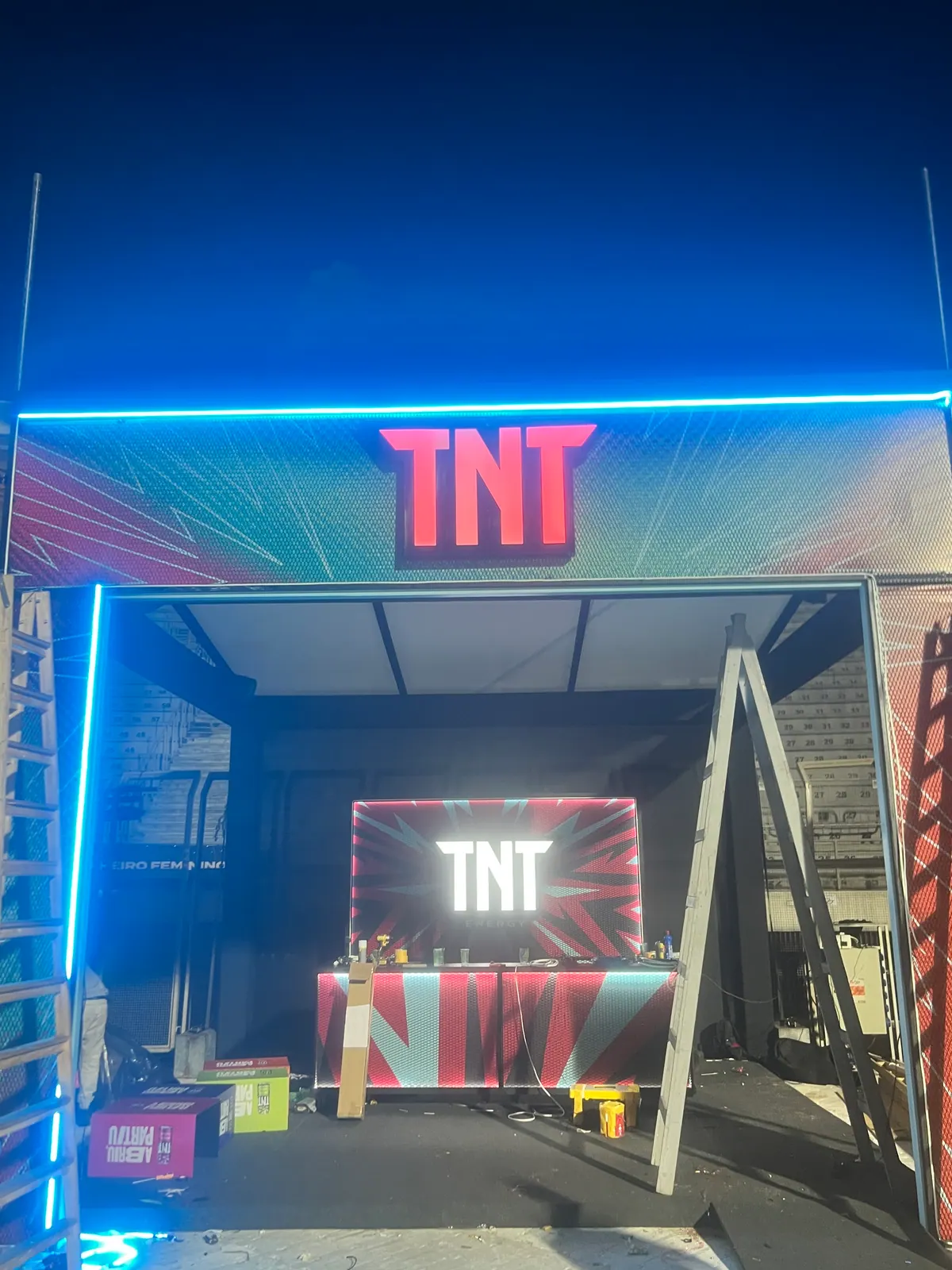 Estruturas de ativação da TNT em festival com portais de neon e bar cenográfico — foto 8